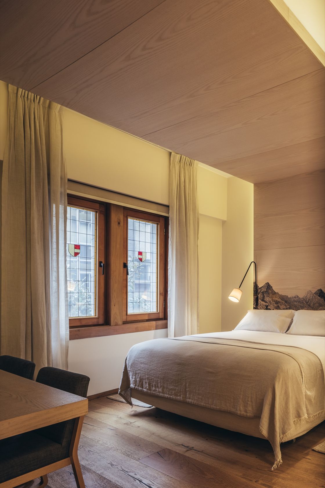 Quarto Deluxe do Hotel Magnolia com vitrais históricos e acabamento em madeira