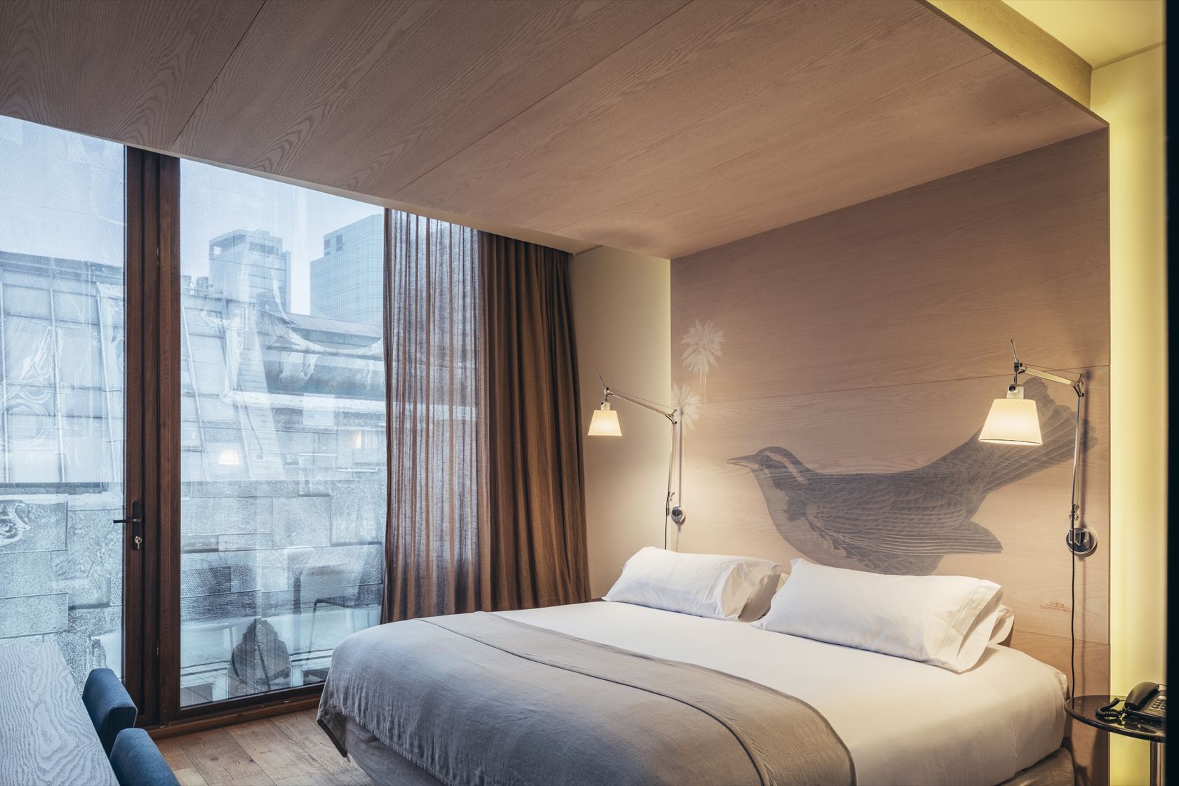 Quarto Deluxe com varanda do Hotel Magnolia e cabeceira ilustrada com ave chilena