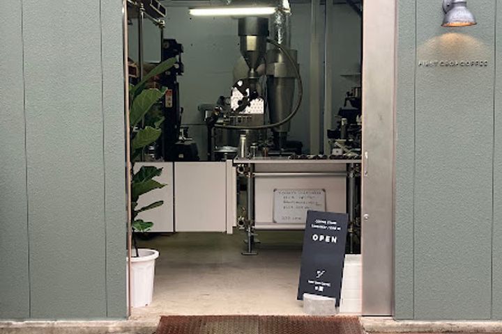 Entrada da First Crop Coffee Japan Roastery, com a torrefação visível ao fundo, em Tóquio
